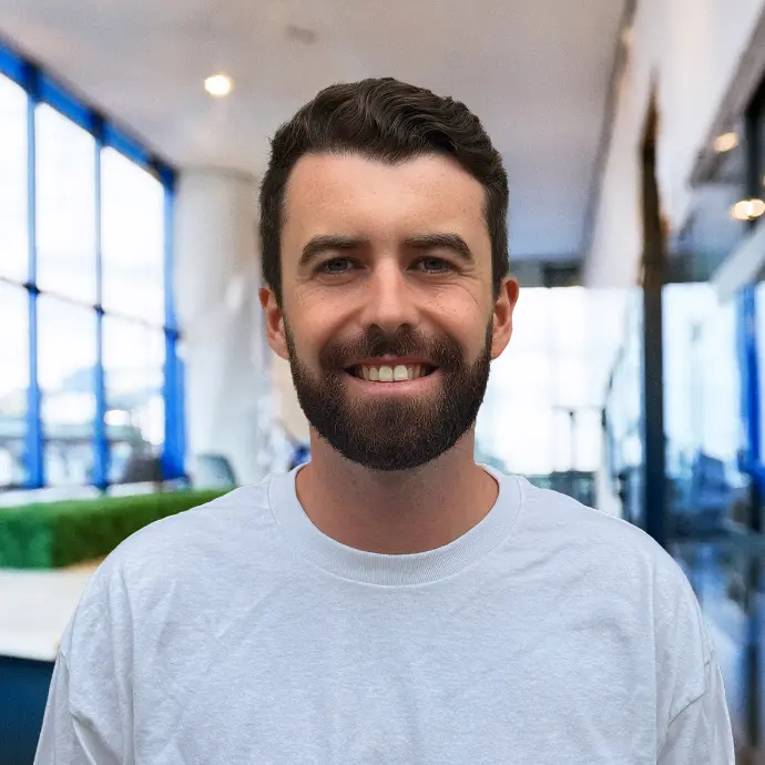 Alexandre Bailly – Co-founder of Frogs&Roos, expert in storytelling and workplace happiness Alexandre Bailly, co-founder of Frogs&Roos, standing with confidence in a professional setting